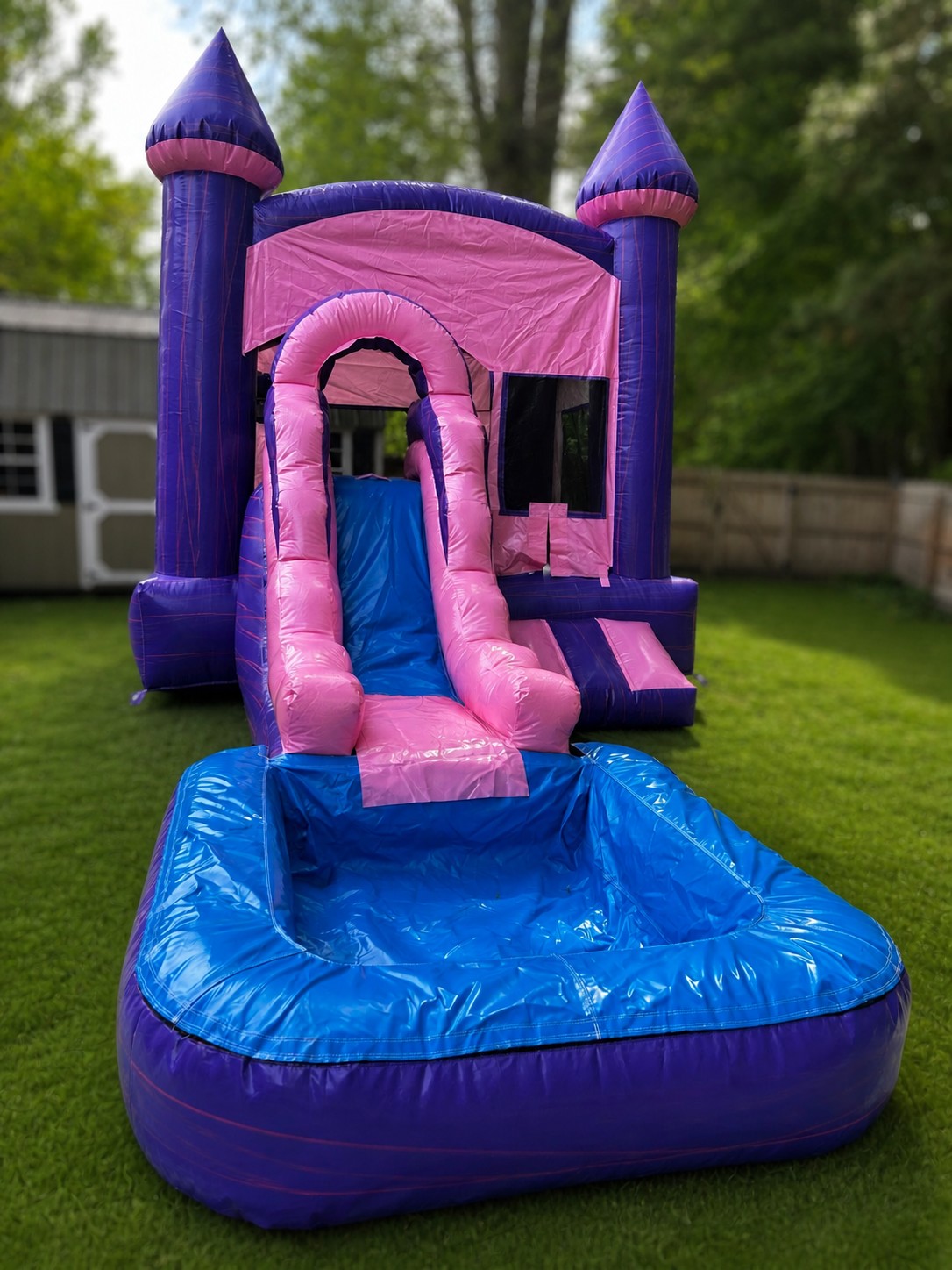 Pink and purple bounce house combo with water slide and splash pool