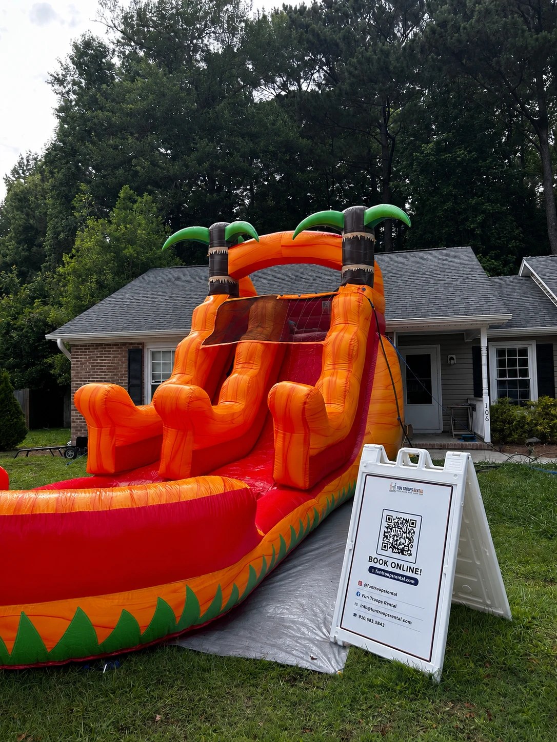 Orange Slide — Real-deal orange tropical water slide with palm-tree towers and a curved splash pool. Run 